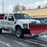 Commercial snow removal crew clearing a business parking lot in Chicago