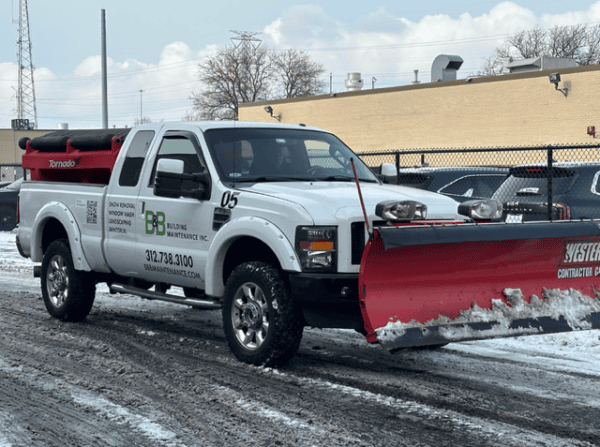 Commercial snow removal crew clearing a business parking lot in Chicago